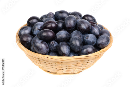 Photo: fresh blue plums in Fruit Basket on the white background fresh blue plums in Fruit Basket on the white background