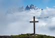 wooden cross in the clouds in the Swiss Alps