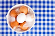 brown and white eggs, feathers in a bowl