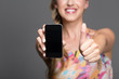 Frau zeigt mit Smartphone
