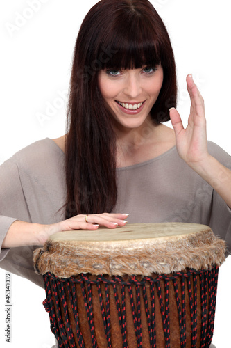 Photo: Woman playing percussion. Woman playing percussion.