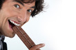 Photo: Excited man eating chocolate bar Excited man eating chocolate bar
