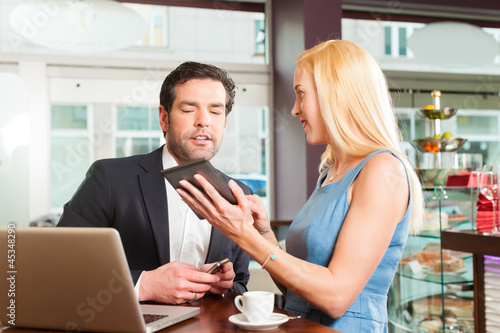 Photo: Arbeitskollegen - ein Mann und eine Frau - sitzen in einem Cafe Arbeitskollegen - ein Mann und eine Frau - sitzen in einem Cafe
