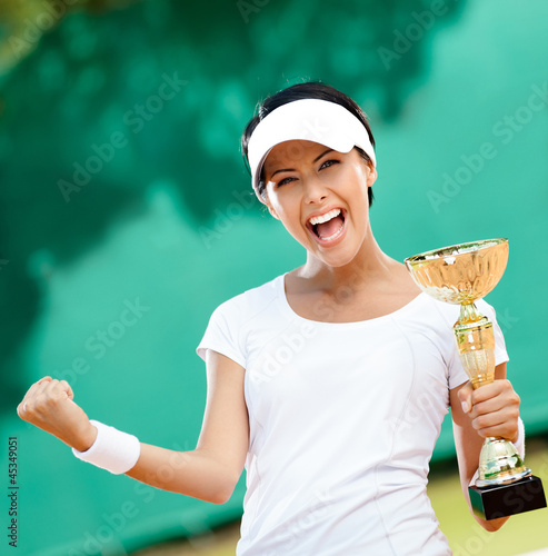 Photo: Female tennis player won the cup at the competition. Victory Female tennis player won the cup at the competition. Victory