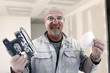 Handyman covered in dust after sanding room