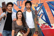 Band standing in front of graffiti
