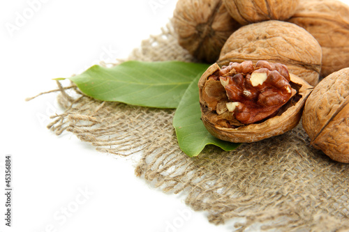Photo: walnuts with green leaves on burlap, isolated on white walnuts with green leaves on burlap, isolated on white