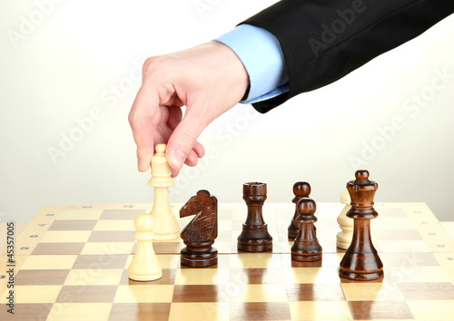Photo: businessman playing chess isolated on white. businessman playing chess isolated on white.