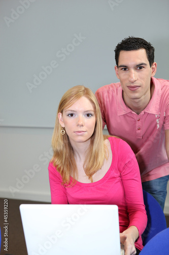 Photo: Teen couple with portable computer Teen couple with portable computer