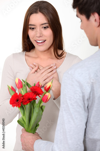 Photo: Woman being surprised with bunch of flowers Woman being surprised with bunch of flowers