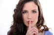 Woman with finger over mouth