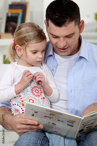 Photo: Father reading a story to his daughter Father reading a story to his daughter