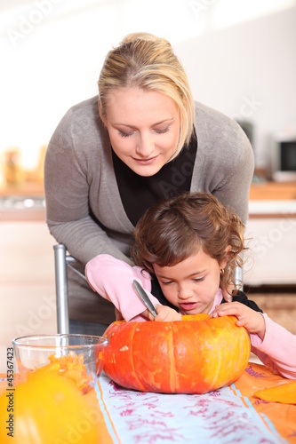 Photo: Mother and daughter carving jack-o-lanterns Mother and daughter carving jack-o-lanterns