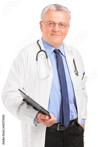 Photo: A mature doctor holding a clipboard and posing A mature doctor holding a clipboard and posing