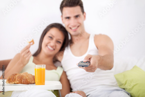 Photo: Couple having breakfast and watching TV Couple having breakfast and watching TV