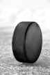 Photo: black hockey puck on ice rink black hockey puck on ice rink