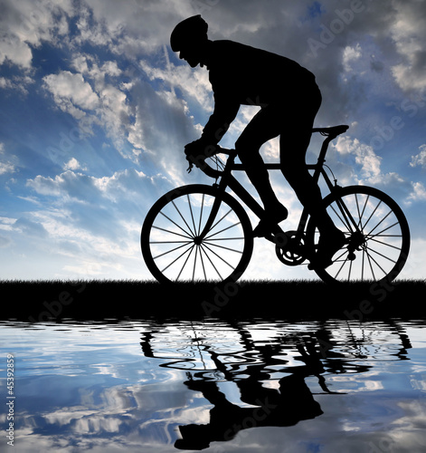 Photo: silhouette of the cyclist riding a road bike at sunset silhouette of the cyclist riding a road bike at sunset