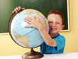 Niño en una escuela abrazando el mundo,planeta tierra.