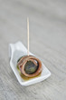 Pincho de anchoa y aceituna en cucharita de cerámica blanca