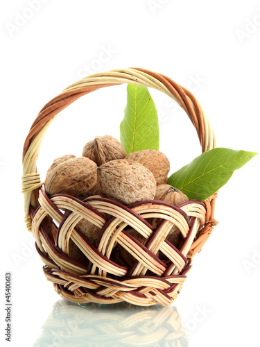Photo: walnuts with green leaves in basket, isolated on white walnuts with green leaves in basket, isolated on white