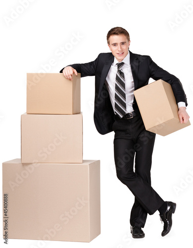 Photo: Manager in suit stands near pile of cardboard boxes Manager in suit stands near pile of cardboard boxes
