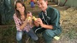 Cheerful couple of duck breeders holding baby ducks