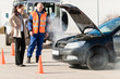 Woman with technician help smoking car engine