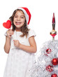 Photo: Happy Little Girl Wearing Santa Hat with heart form lollipop by Happy Little Girl Wearing Santa Hat with heart form lollipop by