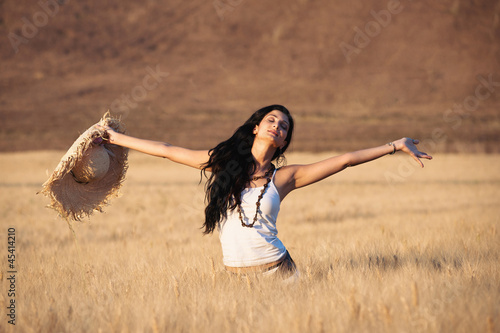 Photo: Young beautiful woman in a wheat field with white dress Young beautiful woman in a wheat field with white dress
