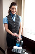 Cheerful waitress opening bottle of beverage