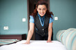 Smiling female executive giving final touches to master bedroom