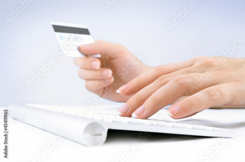 Photo: Woman's hands using credit card and computer keyboard Woman's hands using credit card and computer keyboard