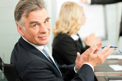 Photo: Applause for a presentation in business meeting Applause for a presentation in business meeting