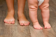 Photo: Legs of mother and baby. First steps. Legs of mother and baby. First steps.