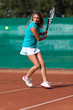 Foto: Young woman playing tennis on a dross field Young woman playing tennis on a dross field