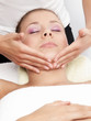 Pretty young woman receives a facial massage - isolated