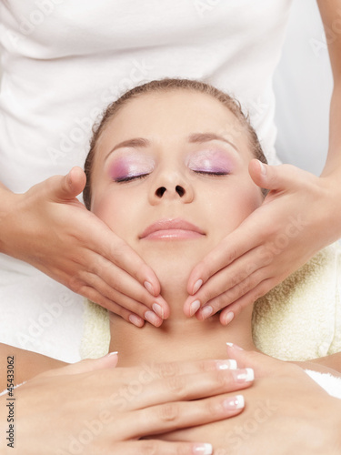 Photo: Pretty young wife receives a face treatment - isolated Pretty young wife receives a face treatment - isolated