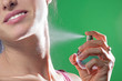 Beautiful young woman spraying parfume