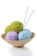 Balls of yarn in basket with knitting needles