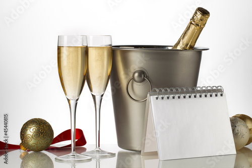 Photo: champagne bottle flutes and ice bucket with christmas baubles champagne bottle flutes and ice bucket with christmas baubles