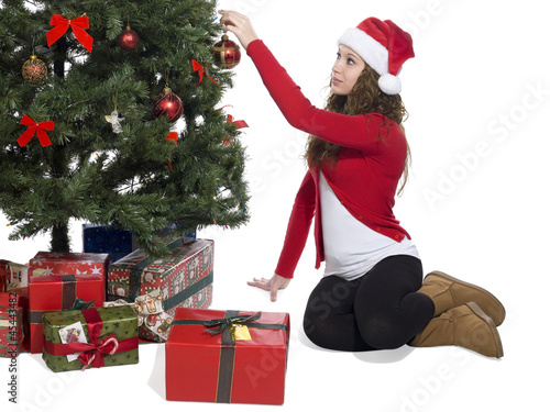 Photo: lady putting a ball decoration in christmas tree lady putting a ball decoration in christmas tree