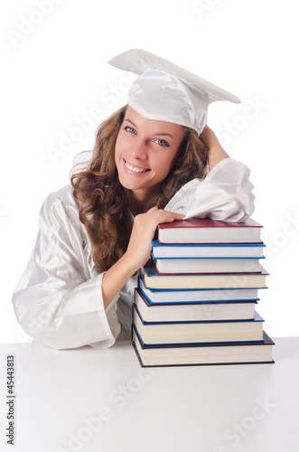 Photo: Happy graduate with lots of books on white Happy graduate with lots of books on white