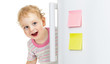 happy child hiding behind fridge door