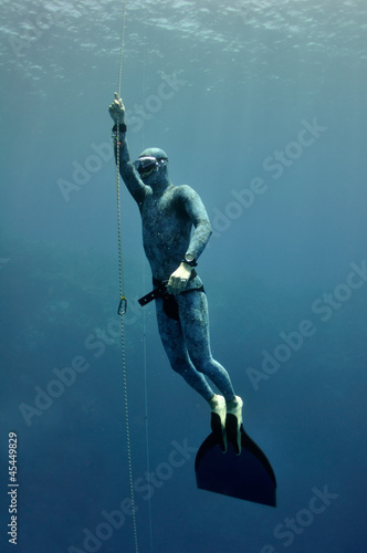 Photo: Freediver raises from the depth by rope Freediver raises from the depth by rope