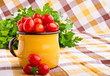 Foto: Yellow mug full of fresh cherry tomatoes Yellow mug full of fresh cherry tomatoes