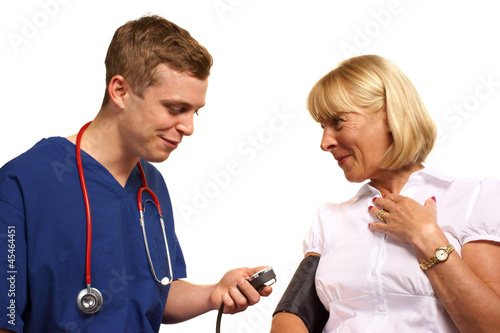 Photo: Doctor taking blood pressure of mature female patient Doctor taking blood pressure of mature female patient