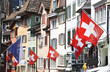 Old street in Zurich decorated with flags for the Swiss National