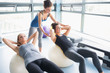 Women doing sit-ups on exercise balls in gym