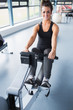 Happy brunette training on row machine