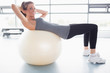 Foto: Woman doing sit-ups on exercise ball Woman doing sit-ups on exercise ball